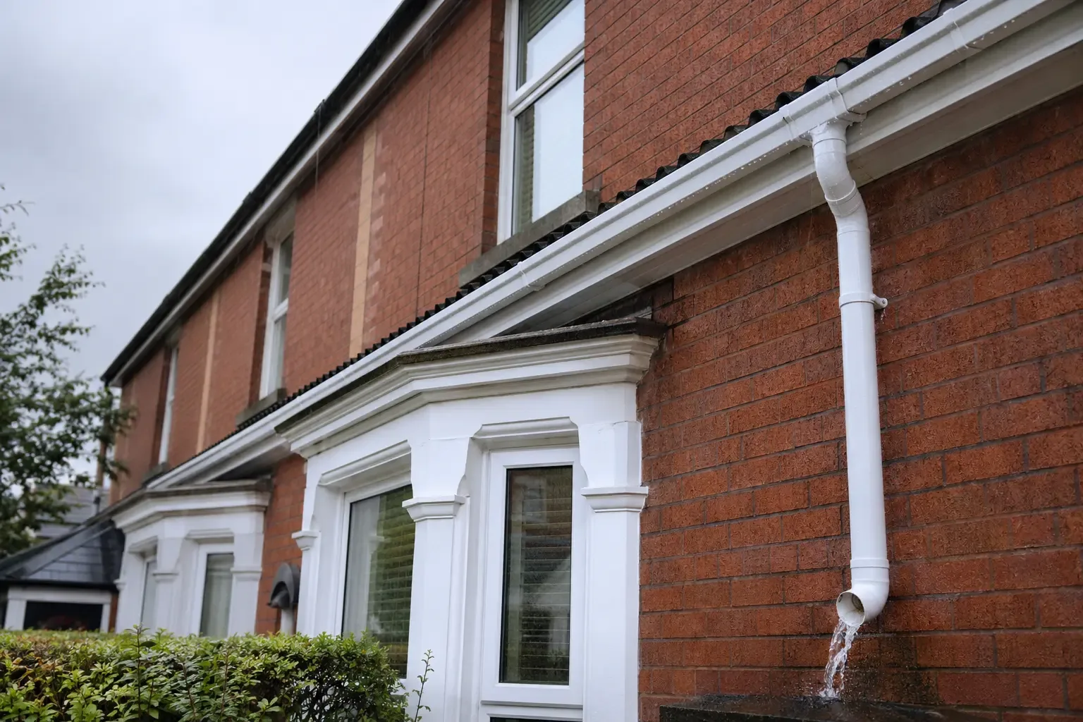 Clear white gutters and downpipe draining correctly in the rain